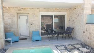 une terrasse avec une table, des chaises et une piscine dans l'établissement Zefyros Suite , Seafront retreat !, à Panormos Rethymno