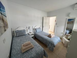 1 dormitorio con 2 camas y espejo en Oasis Blue - beautiful 1 bedroom apartment on private complex with pool, en Tías