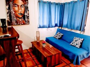 a living room with a blue couch and a table at Jungle Beach Bungalow with AC & Fiber optic in Puerto Viejo