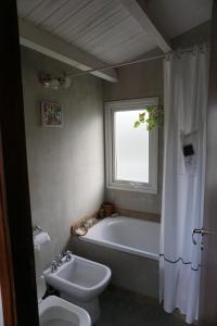 a bathroom with a tub and a toilet and a sink at Casa Towanda in San Carlos de Bariloche