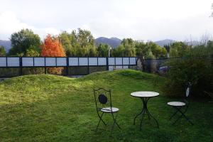 two chairs and two tables in the grass at Casa Towanda in San Carlos de Bariloche