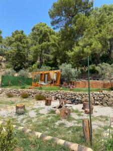 a garden with a pile of logs and a fence at Tiny Mini House in Dalaman
