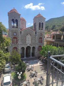 un gran edificio de piedra con una torre de reloj en Hotel Koutriaris en Distomo