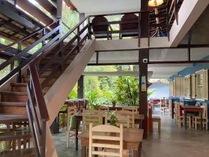 a staircase in a restaurant with tables and chairs at Pousada Recanto das Estrelas in Abraão