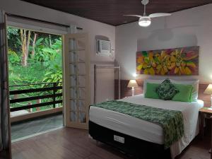 1 dormitorio con 1 cama con una pintura en la pared en Pousada Recanto das Estrelas, en Abraão