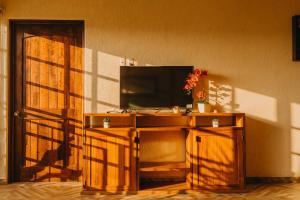 uma televisão num suporte de madeira num quarto em Primavera Suites em Zihuatanejo