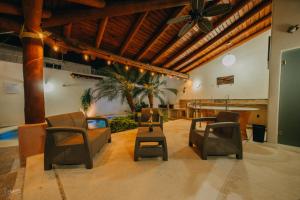 sala de estar con sillas y ventilador de techo en Primavera Suites en Zihuatanejo