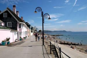 a street light on a sidewalk next to the beach at Private apartment, parking, sea and country views in Lyme Regis