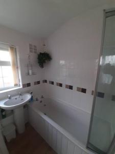 a bathroom with a sink and a bath tub and a sink at Private apartment, parking, sea and country views in Lyme Regis