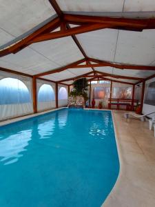 a large swimming pool with a large ceiling at Hosteria Valle Azul in Villa del Dique +32 photos