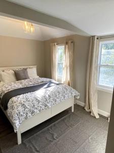 a bedroom with a bed and two windows at Sauble Shores Waterfront Hideaway in Sauble Beach