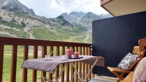 een tafel op een balkon met uitzicht op de bergen bij Superbe 3 pieces vue panoramique pied des pistes in La Mongie