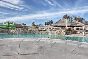 a resort with a swimming pool with a thatch roof at Margaritaville Resort Golf Course Oasis with Hot Tub in Osage Beach