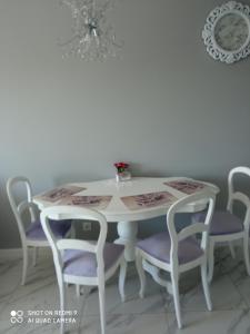 een eettafel met paarse stoelen en een witte tafel bij Apartament Lawendowy in Kudowa-Zdrój