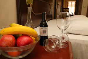 a table with a bowl of fruit and two wine glasses at KALE EVİ BUTİK OTEL 