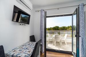 - une chambre avec une porte coulissante en verre menant à une terrasse dans l'établissement Villa Laura View, à Novalja