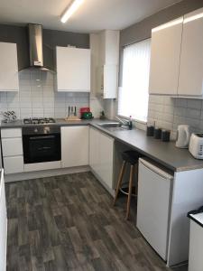 Sheffield spa view 2 bed house free parking في شيفيلد: مطبخ بدولاب بيضاء وقمة كونتر