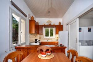 a kitchen with a table and chairs and a refrigerator at New! PaxosWhite Sea View Apartments & Studios! in Gaios