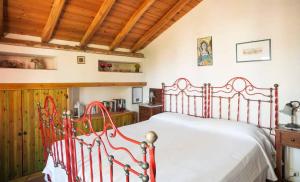una camera con letto rosso in una stanza con soffitti in legno di B&B La Casa del Ficus a Stazzo