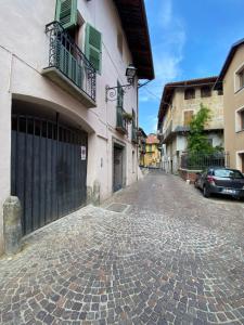 une rue pavée avec un bâtiment et une voiture dans l'établissement Casa Corona Grossa, à Saluces