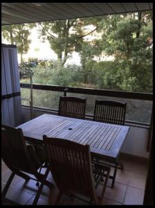 a wooden table and four chairs on a porch with a table and a window at Apartamento Bamuxela in Vigo