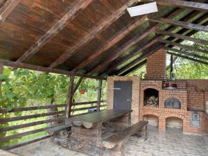 patio con chimenea de ladrillo y mesa de madera en Gospodaria Klaus, en Rozavlea