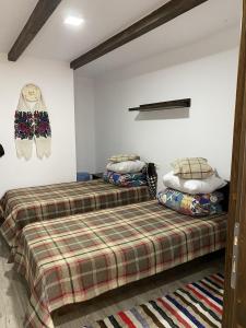 two twin beds in a room with white walls at Gospodaria Klaus in Rozavlea