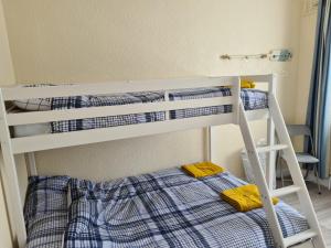 two bunk beds in a room with a ladder at 5 Berth bungalow in Mablethrorpe (Joe's Place) in Mablethorpe