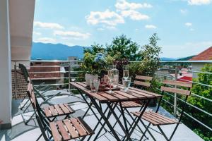 einen Holztisch und Stühle auf dem Balkon in der Unterkunft Villa Cerkniško jezero in Cerknica