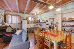 a kitchen and living room with a couch and a table at Can MartiPol in La Pobla de Lillet