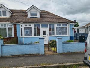 a blue house with a fence in front of it at 5 Berth bungalow in Mablethrorpe (Joe's Place) in Mablethorpe