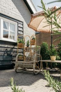 un groupe de chaises, une table et un parasol dans l'établissement Logement Cornelia - Tholen, Zeeland, à Tholen