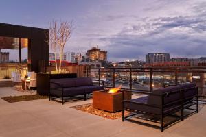 a rooftop patio with a fire pit and a city skyline at Sentral SoBro in Nashville