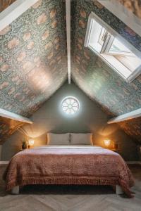 a bedroom with a large bed in a attic at Logement Cornelia - Tholen, Zeeland in Tholen