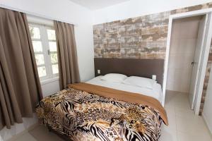 a bedroom with a bed with a tiger patterned bedspread at Hotel Fazenda Casarão do Vale Hotel in Massaranduba
