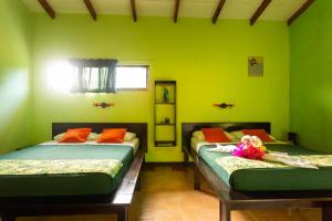 a bedroom with two beds with a doll laying on the bed at Hotel Boutique La Casa de las Flores in Cahuita