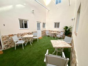 a room with tables and chairs and a stone wall at CASA SOLE - Apartamento Playa San Juan NR. 4 in Guía de Isora