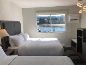 a hotel room with two beds and a window at The Spot at Porpoise Bay in Sechelt