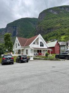 a house with cars parked in a parking lot at Undredal Fjord Apartments in Undredal
