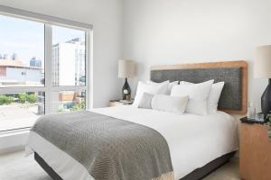 a bedroom with a white bed and a large window at Sentral SoBro in Nashville