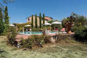 uma casa com uma piscina com guarda-sóis e uma casa em Villa Soiana em Soianella