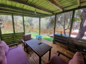 a screened in porch with a table and chairs at Kabak Lost Forest VİLLA in Kızılcakaya