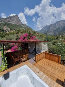 a balcony with a hot tub and a view of mountains at Kabak Lost Forest VİLLA in Kızılcakaya