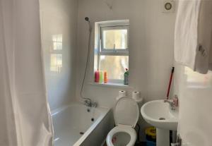La salle de bains blanche est pourvue de toilettes et d'un lavabo. dans l'établissement Beautiful First Floor one bedroom apartment B Walthamstow, à Londres