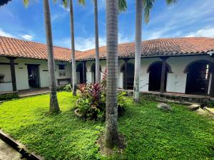 a building with palm trees in front of it at Hotel Boutique Posada Las Trampas in Honda