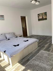 a bedroom with a bed with a blue and white comforter at Dana Studio in Tulcea