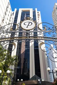 a gate with a clock on it in front of a building at Flat Charmoso Jardim Paulista in Sao Paulo