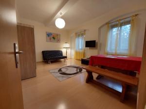 a living room with a red bed and a couch at Das Eckhaus in Murau