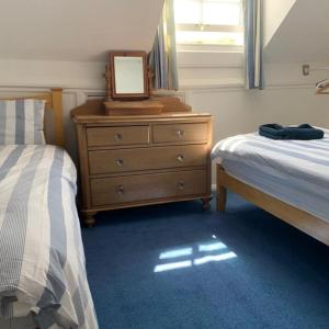 um quarto com 2 camas e uma cómoda com um espelho em Sea Haven holiday cottage at Staithes em Staithes