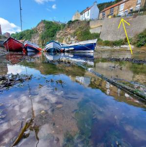 a group of boats sitting in the water at Sea Haven holiday cottage at Staithes in Staithes